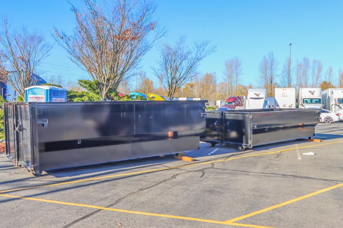 Professional dumpster rental service with roll-off container on residential driveway in Perinton